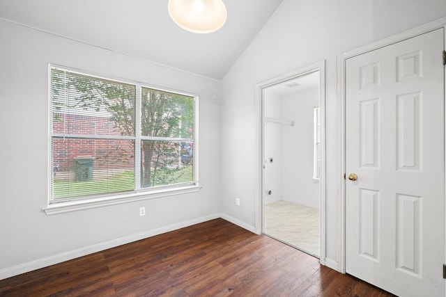 150 Primrose Blvd, Kyle, TX 78640 - unfurnished bedroom with multiple windows, lofted ceiling, and dark wood-style flooring