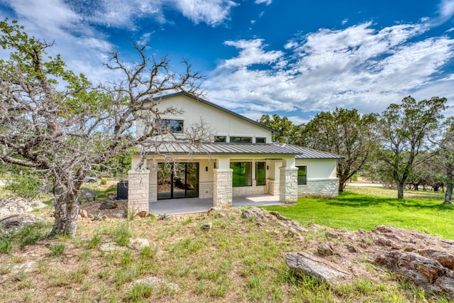 625 Desert Rose N, Horseshoe Bay, TX 78657 - back of property with a patio area, a yard, a standing seam roof, metal roof, and stone siding