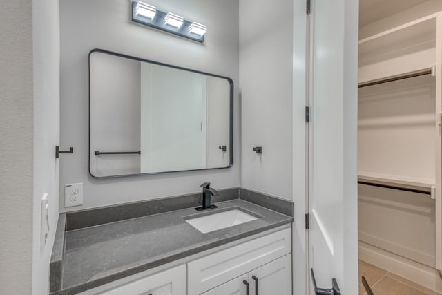 625 Desert Rose N, Horseshoe Bay, TX 78657 - bathroom featuring vanity, a walk in closet, and tile patterned flooring