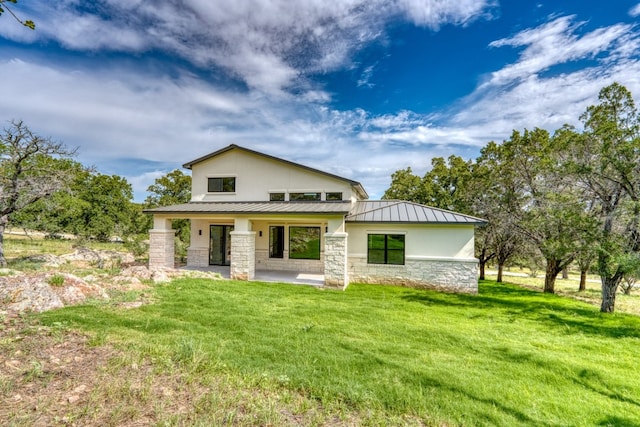 625 Desert Rose N, Horseshoe Bay, TX 78657 - back of property with stone siding, a standing seam roof, a yard, metal roof, and stucco siding