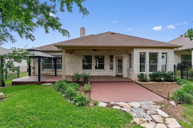 105 Longhorn Cavern Cv, Georgetown, TX 78633 - back of property with a ceiling fan, a patio area, a gazebo, a chimney, and stone siding