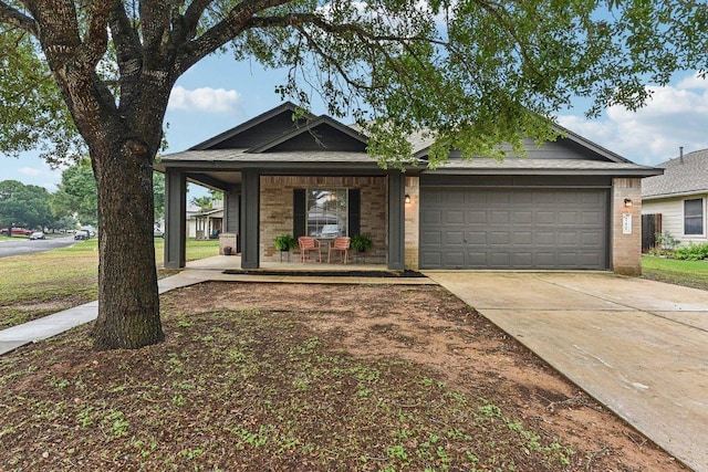 717 Blair Ave, Bastrop, TX 78602 - view of front of property with a garage, driveway, a porch, and brick siding