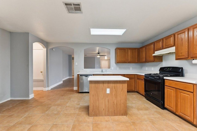 717 Blair Ave, Bastrop, TX 78602 - kitchen with black gas stove, dishwasher, under cabinet range hood, a kitchen island, and light countertops