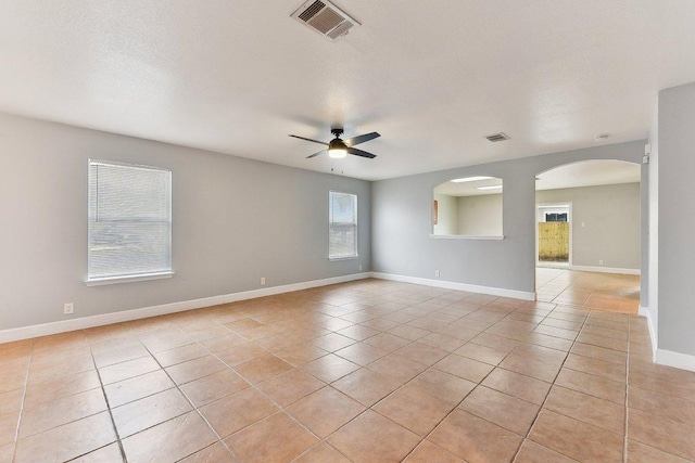 717 Blair Ave, Bastrop, TX 78602 - empty room featuring a ceiling fan, light tile patterned floors, arched walkways, and baseboards