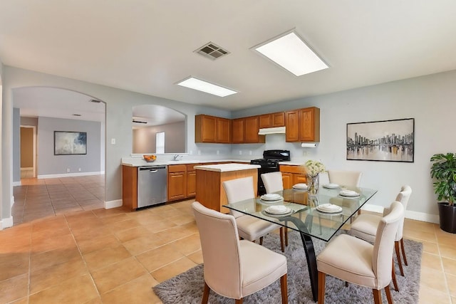 717 Blair Ave, Bastrop, TX 78602 - kitchen with stainless steel dishwasher, black range with gas stovetop, light tile patterned flooring, under cabinet range hood, and light countertops