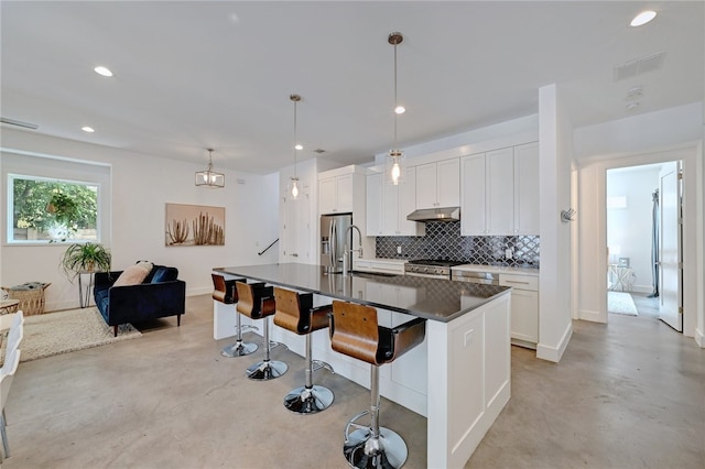 5506 Evans Ave Unit 1, Austin, TX 78751 - kitchen with finished concrete floors, backsplash, a kitchen breakfast bar, white cabinets, and recessed lighting