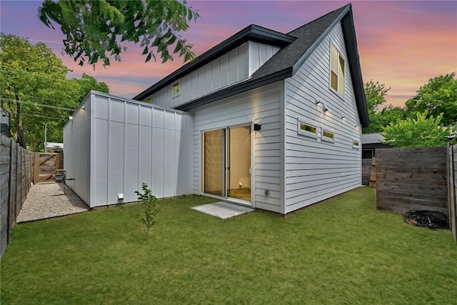 5506 Evans Ave Unit 1, Austin, TX 78751 - back of house at dusk featuring a fenced backyard, a shingled roof, board and batten siding, and an outdoor structure