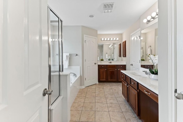 3929 Vallarta Ln, Round Rock, TX 78681 - bathroom with a garden tub, two vanities, tile patterned floors, and a shower stall