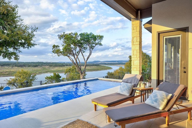 view of swimming pool featuring a water view and fence