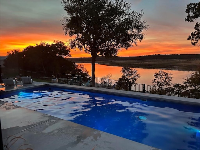 view of pool with a patio and a water view