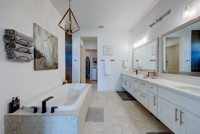 bathroom featuring double vanity, a bath, tile patterned flooring, and a chandelier