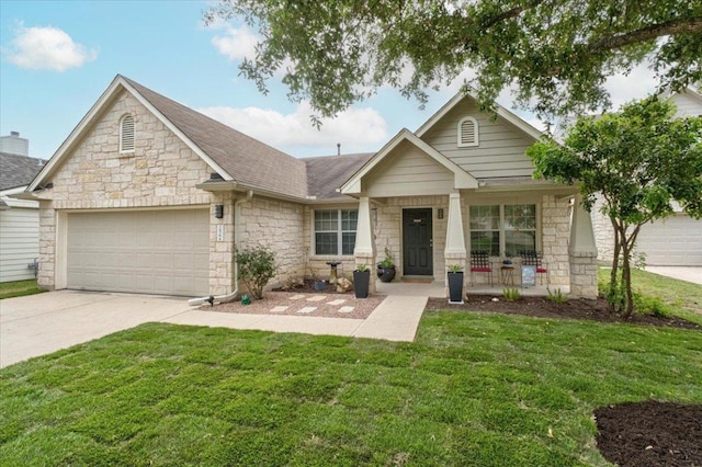 view of front of property featuring stone siding, a garage, driveway, and a front yard