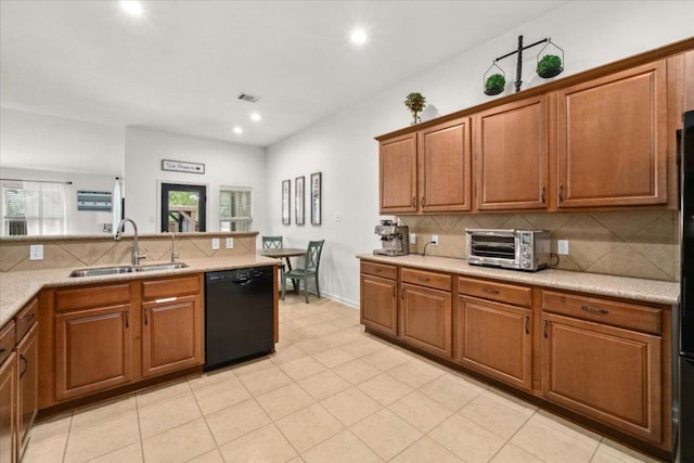 kitchen featuring a sink, black dishwasher, brown cabinetry, light countertops, and decorative backsplash