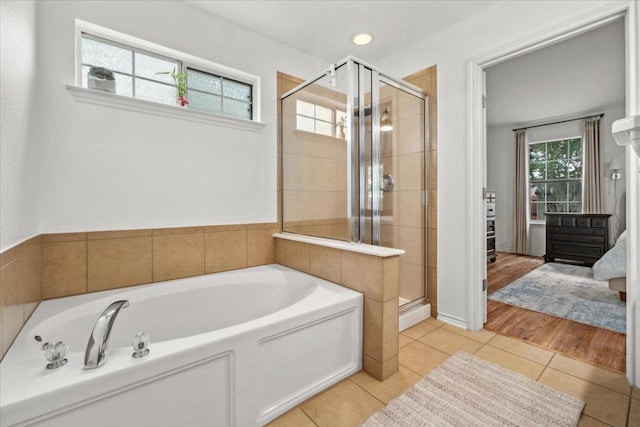 ensuite bathroom with tile patterned floors, a garden tub, and a stall shower