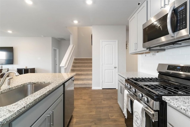 118 Ballyneal Ln, San Marcos, TX 78666 - kitchen with stainless steel appliances, light stone countertops, dark wood-type flooring, recessed lighting, and backsplash