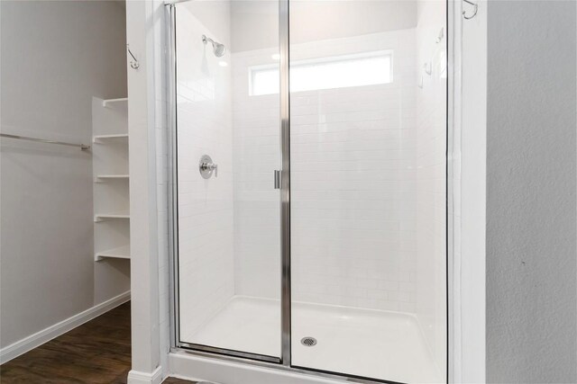 118 Ballyneal Ln, San Marcos, TX 78666 - bathroom with a stall shower, wood finished floors, and a spacious closet
