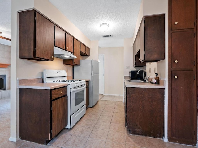 3513 Westchester Ave, Austin, TX 78759 - kitchen featuring white appliances, under cabinet range hood, a textured ceiling, light countertops, and light tile patterned floors