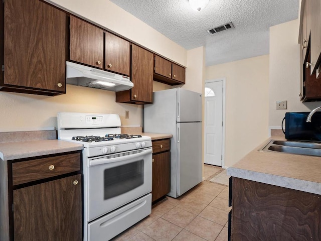 3513 Westchester Ave, Austin, TX 78759 - kitchen with white appliances, under cabinet range hood, a sink, a textured ceiling, and light countertops