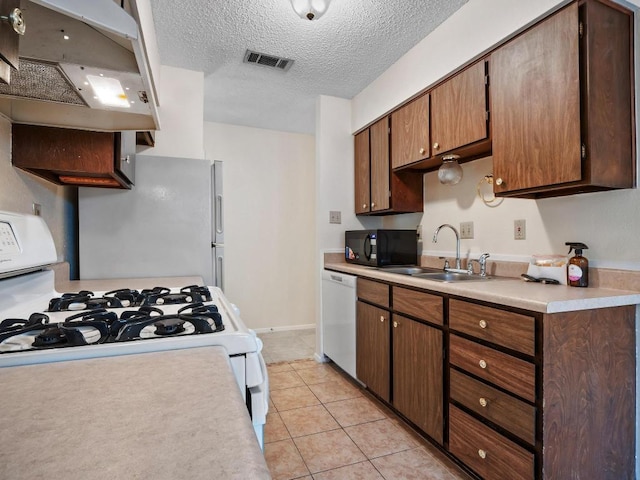 3513 Westchester Ave, Austin, TX 78759 - kitchen featuring white appliances, range hood, light countertops, a textured ceiling, and a sink
