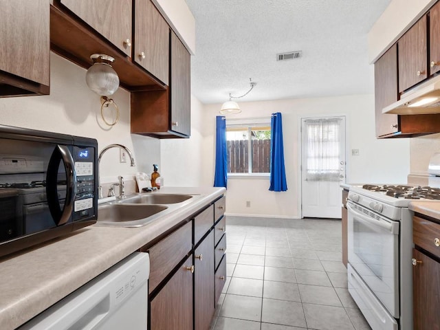3513 Westchester Ave, Austin, TX 78759 - kitchen with white appliances, a sink, light countertops, under cabinet range hood, and a textured ceiling