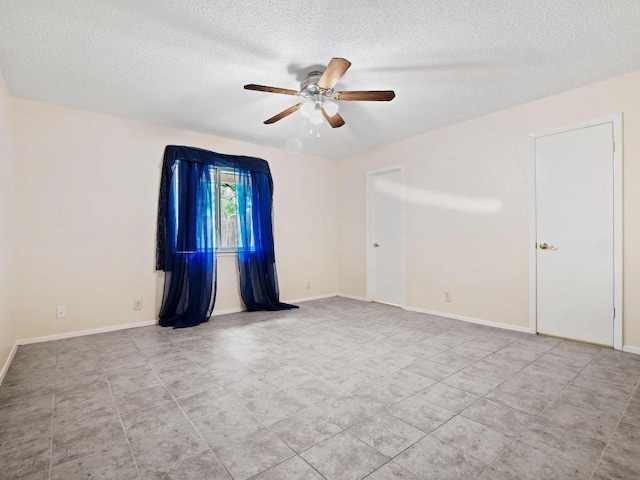 3513 Westchester Ave, Austin, TX 78759 - empty room with a ceiling fan, a textured ceiling, tile patterned floors, and baseboards