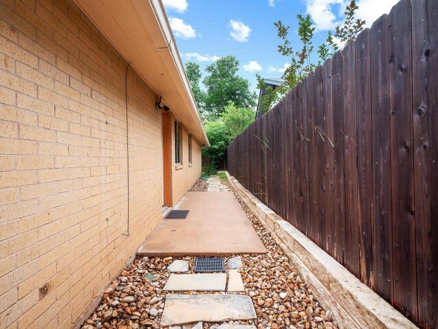 3513 Westchester Ave, Austin, TX 78759 - view of side of home featuring fence, brick siding, and a patio area