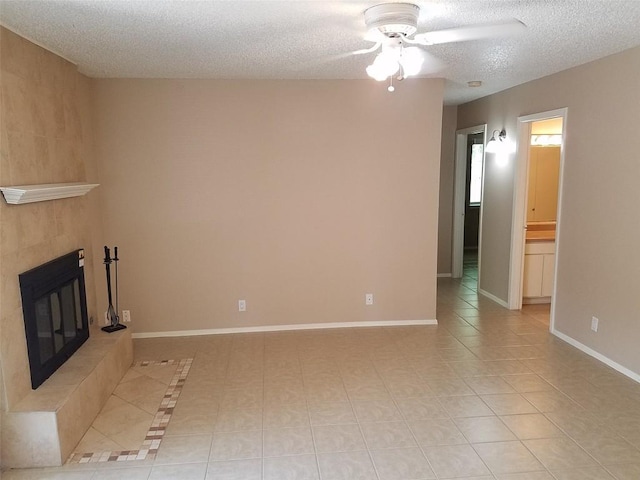 3513 Westchester Ave, Austin, TX 78759 - unfurnished living room with ceiling fan, a textured ceiling, a tile fireplace, light tile patterned floors, and baseboards