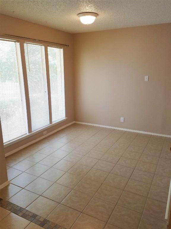 3513 Westchester Ave, Austin, TX 78759 - spare room featuring a textured ceiling, baseboards, and light tile patterned flooring