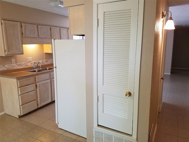 3513 Westchester Ave, Austin, TX 78759 - kitchen with freestanding refrigerator, a sink, light tile patterned floors, light countertops, and light brown cabinetry
