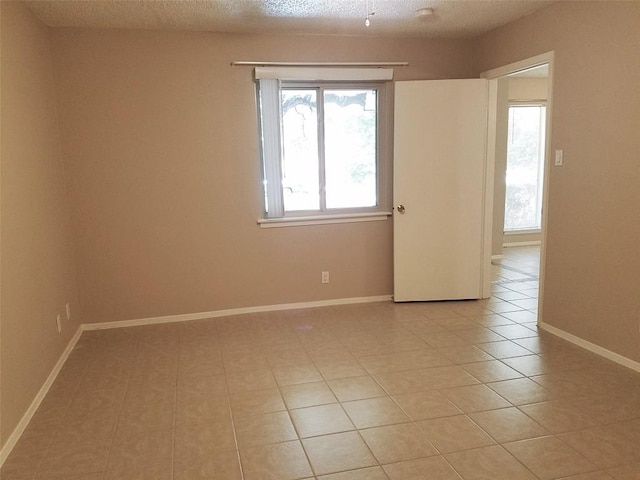 3513 Westchester Ave, Austin, TX 78759 - unfurnished room featuring light tile patterned floors, baseboards, and a textured ceiling