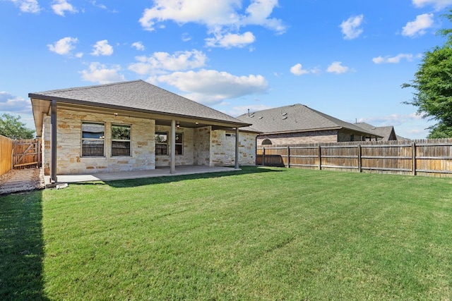 back of property with a patio area, stone siding, and a shingled roof