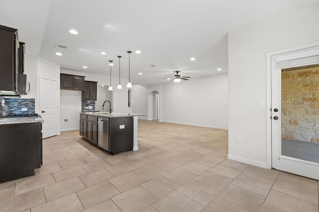 kitchen with a sink, arched walkways, ceiling fan, recessed lighting, and backsplash