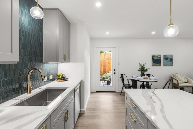 kitchen with gray cabinets, a sink, recessed lighting, wood finished floors, and decorative backsplash