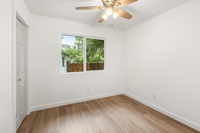 unfurnished bedroom with wood finished floors, baseboards, and a ceiling fan