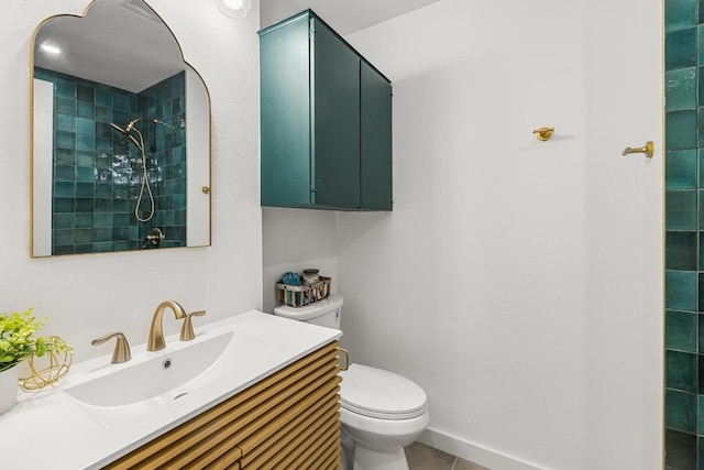 bathroom featuring toilet, a tile shower, tile patterned floors, and vanity