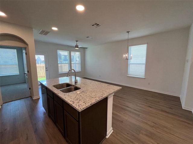 8517 Wellspring Loop, Round Rock, TX 78665 - kitchen featuring dark wood-style floors, open floor plan, a center island with sink, recessed lighting, and light stone countertops
