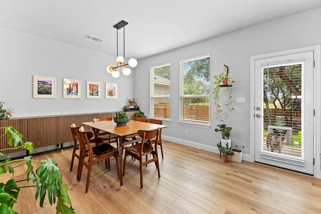 dining room featuring light wood finished floors and a chandelier