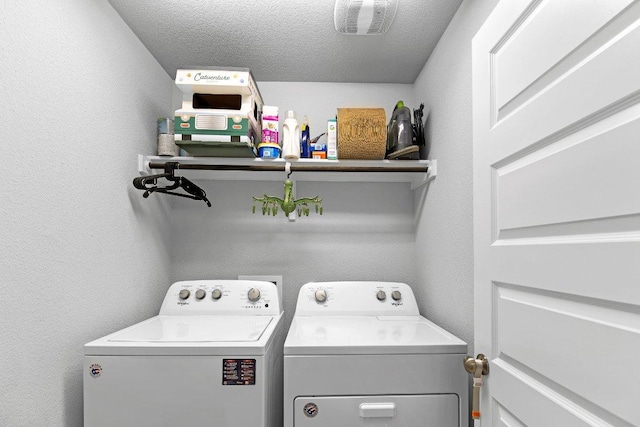 clothes washing area featuring independent washer and dryer and a textured ceiling