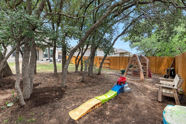 fenced backyard with a playground