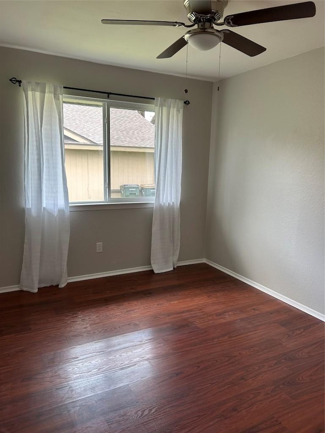unfurnished room with ceiling fan, baseboards, and dark wood-type flooring