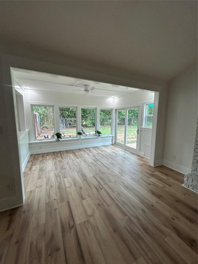 unfurnished living room with wood finished floors and baseboards