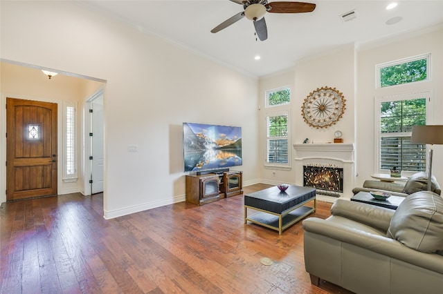 104 Rivalto Cir Unit 1, Lakeway, TX 78734 - living area with crown molding, a warm lit fireplace, hardwood / wood-style flooring, ceiling fan, and recessed lighting