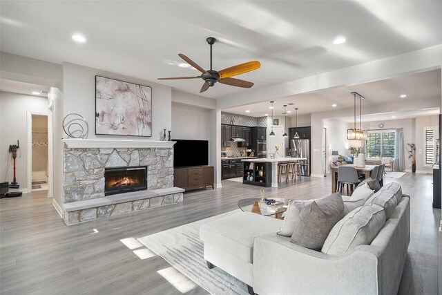 225 Escarpment Way, Cedar Park, TX 78613 - living area featuring a ceiling fan, a fireplace, recessed lighting, light wood-style flooring, and baseboards
