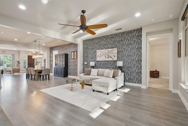 225 Escarpment Way, Cedar Park, TX 78613 - living area featuring an accent wall, wallpapered walls, a ceiling fan, baseboards, and wood finished floors