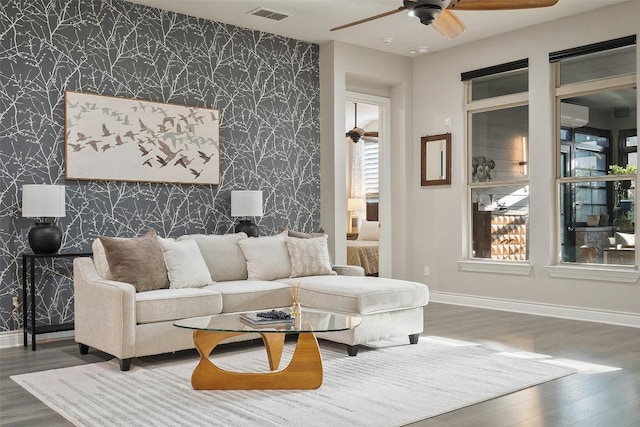 225 Escarpment Way, Cedar Park, TX 78613 - living area with wallpapered walls, an accent wall, a ceiling fan, baseboards, and wood finished floors