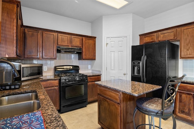 3908 Whitey Ford Way, Round Rock, TX 78665 - kitchen featuring black appliances, under cabinet range hood, a kitchen island, dark stone counters, and tasteful backsplash