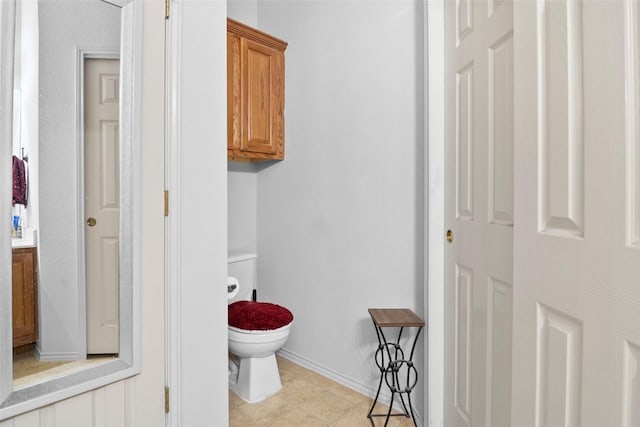 bathroom with toilet and baseboards