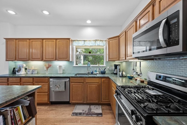 10978 W Cave Blvd, Dripping Springs, TX 78620 - kitchen with appliances with stainless steel finishes, a sink, light wood-style flooring, decorative backsplash, and brown cabinets