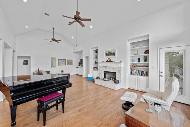 10978 W Cave Blvd, Dripping Springs, TX 78620 - living room with a ceiling fan, built in shelves, high vaulted ceiling, a fireplace, and recessed lighting