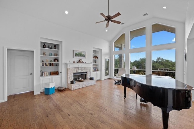 10978 W Cave Blvd, Dripping Springs, TX 78620 - living area with built in features, a ceiling fan, a fireplace, recessed lighting, and light wood-style flooring